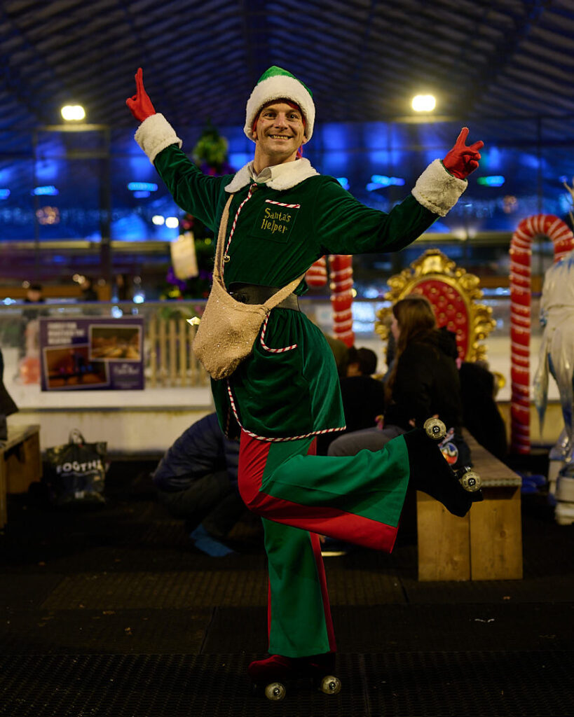 Rollerskating elf posing with 1 leg in the air