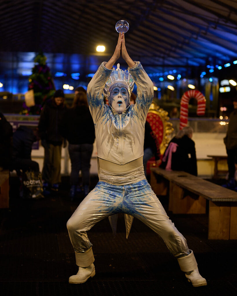 The Ice King performs in a white, silver and blue shimery costumes with his magical glass orb