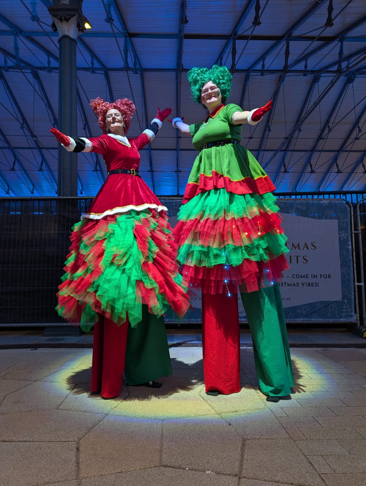 2 stiltwalkers in red and green costumes